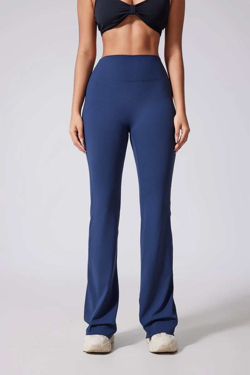 Person wearing blue high-waisted pants on a plain background