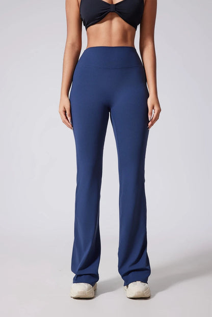 Person wearing blue high-waisted pants on a plain background