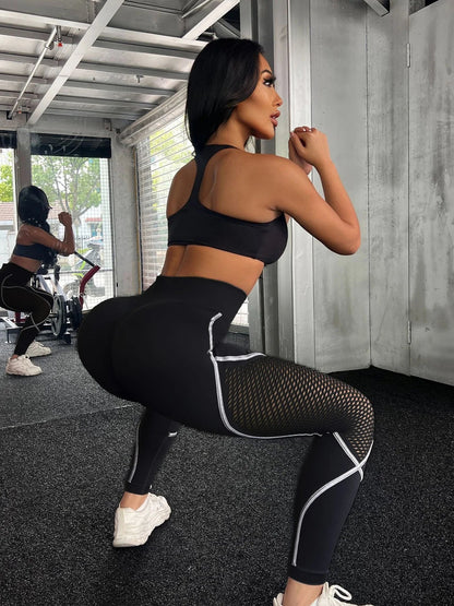 Woman in black athletic wear posing in a gym setting- Stealth Mode Black