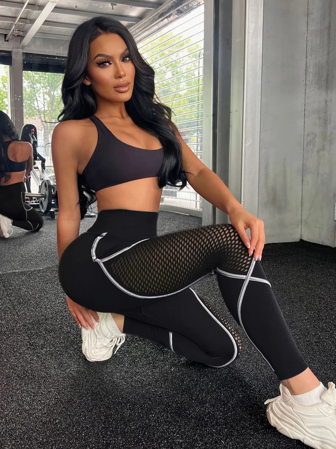 Woman in black athletic wear posing in a gym setting- Stealth Mode Black