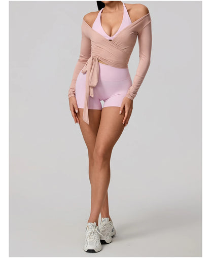 Person wearing a pink and beige outfit with white sneakers on a light gray background