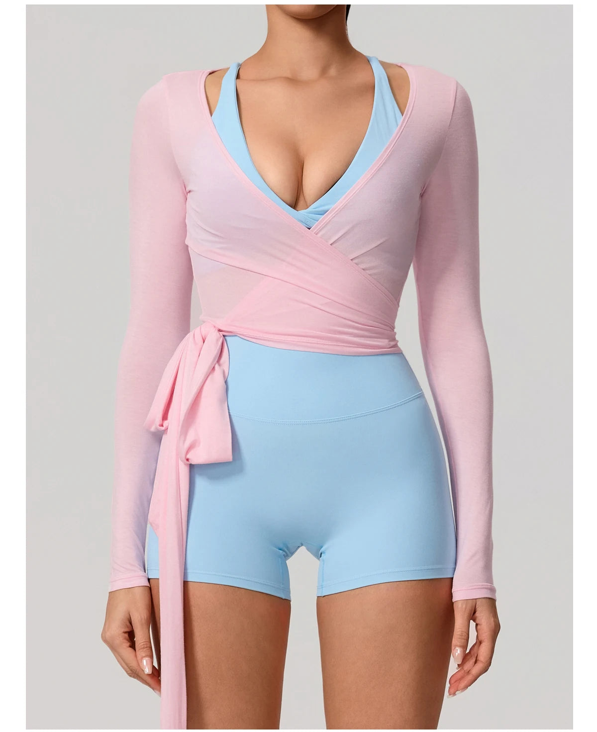 Pastel pink and blue outfit with long-sleeve top and shorts on a plain background