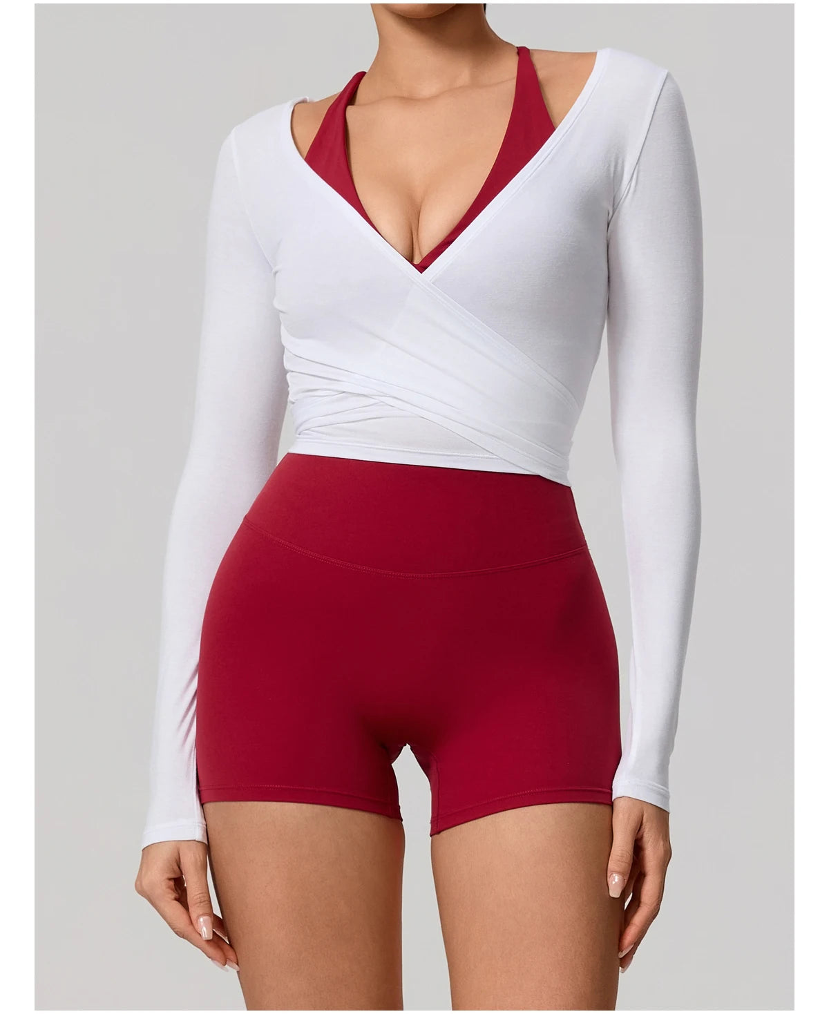 White long-sleeve top and red shorts on a plain background