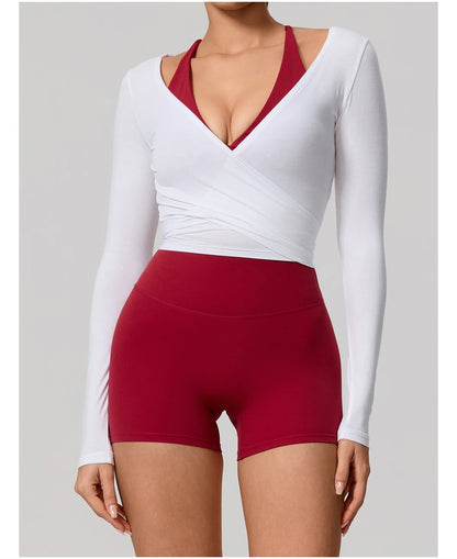 White long-sleeve top and red shorts on a plain background
